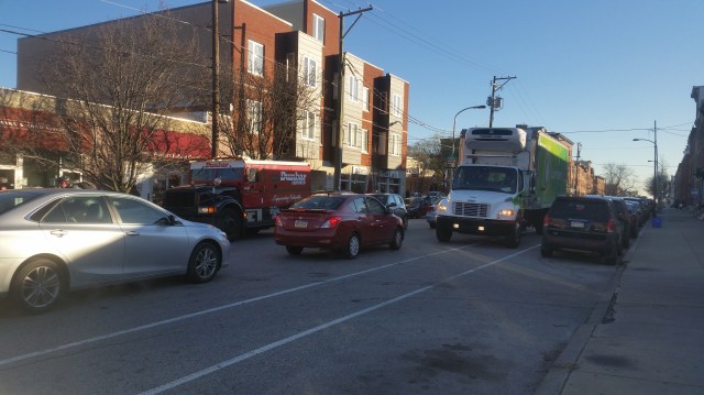 Both bike lanes blocked (and traffic lanes fouled) by trucks facing west, 1900 block of Fairmount Ave.